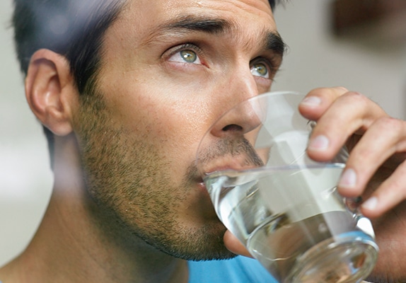 Homme buvant de l'eau du robinet