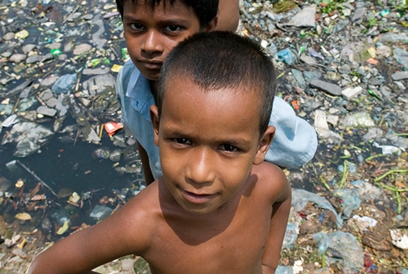 Enfants autour d'un cours d'eau sale